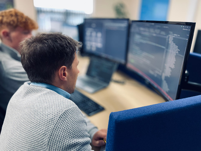 Senior developer at PSP IT training a new developer on software development